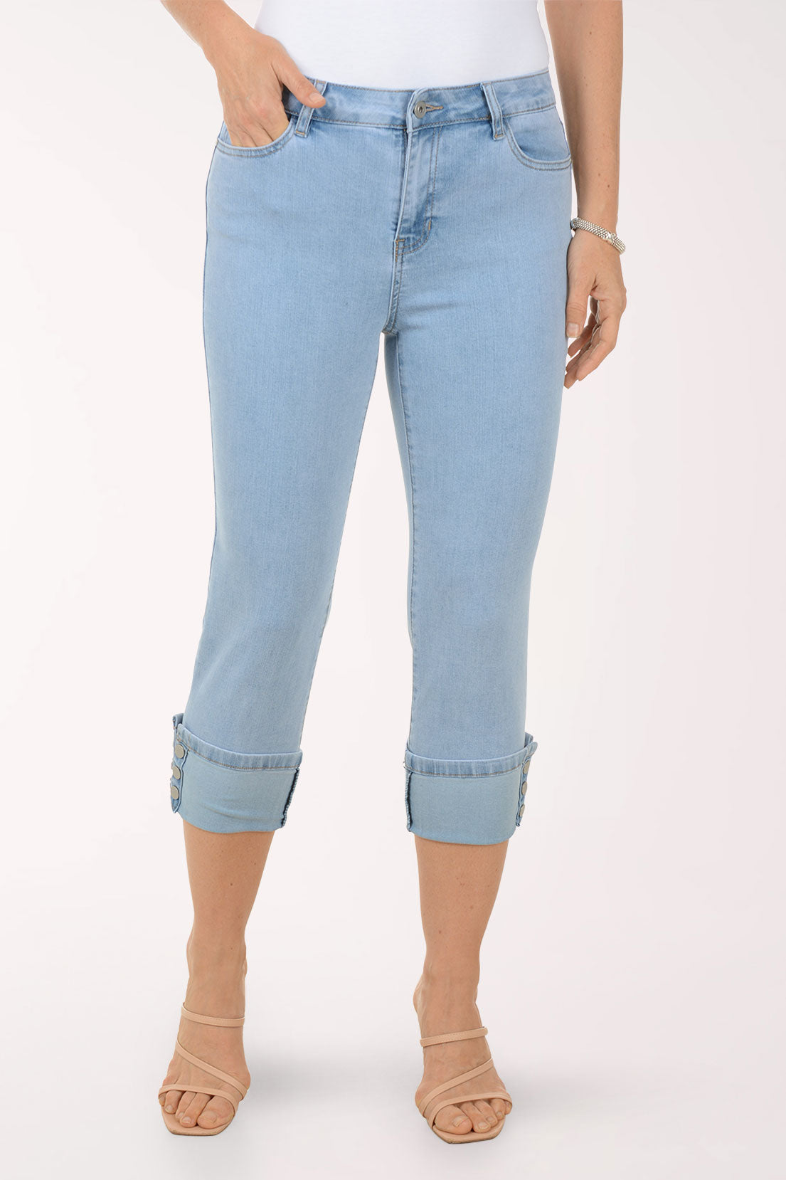 Light blue jeans with rolled-up cuffs worn by a person on a white background
