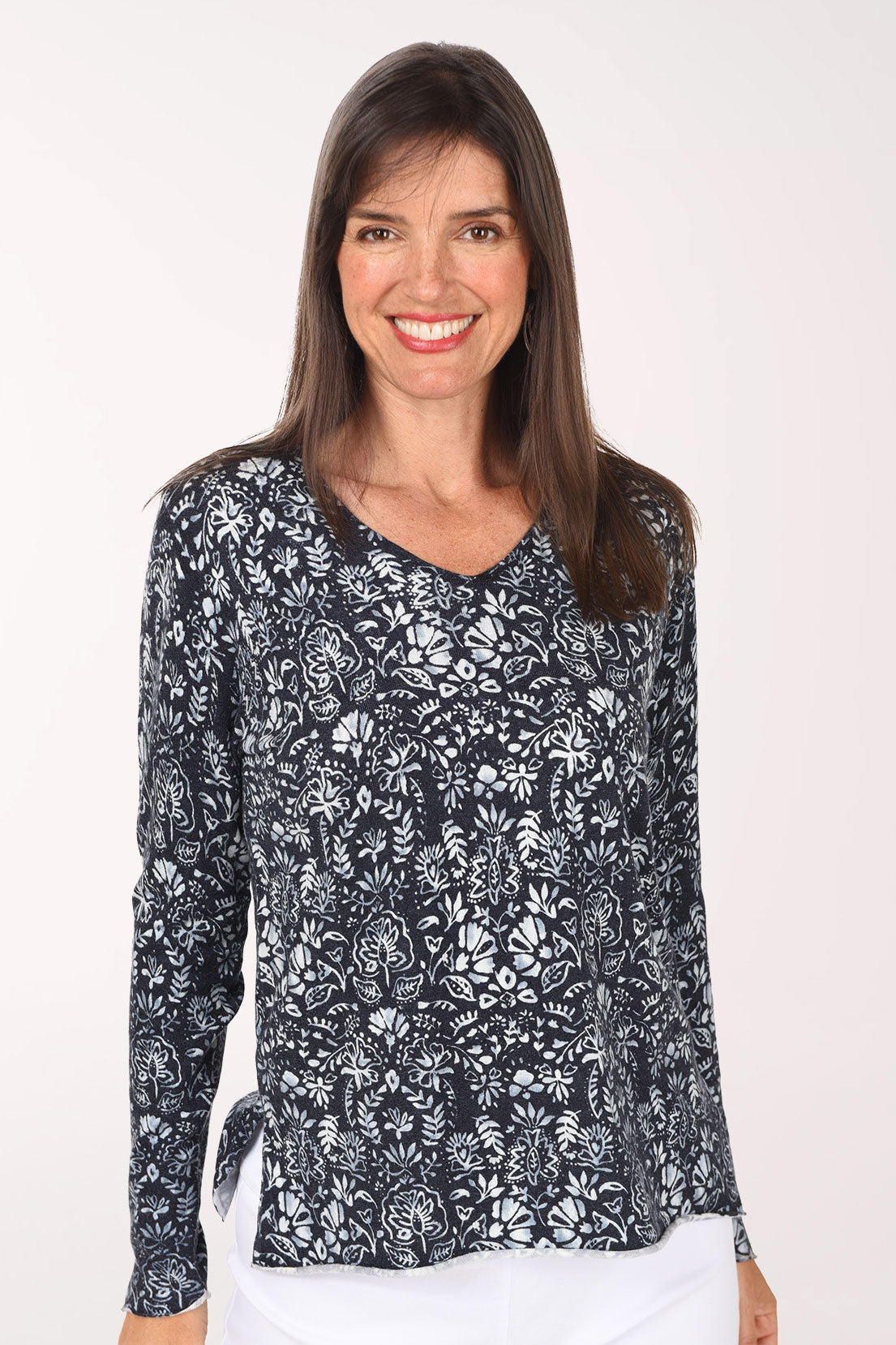 A close view of the navy botanical print sweater showing the V-neckline and detailed white leaf print.