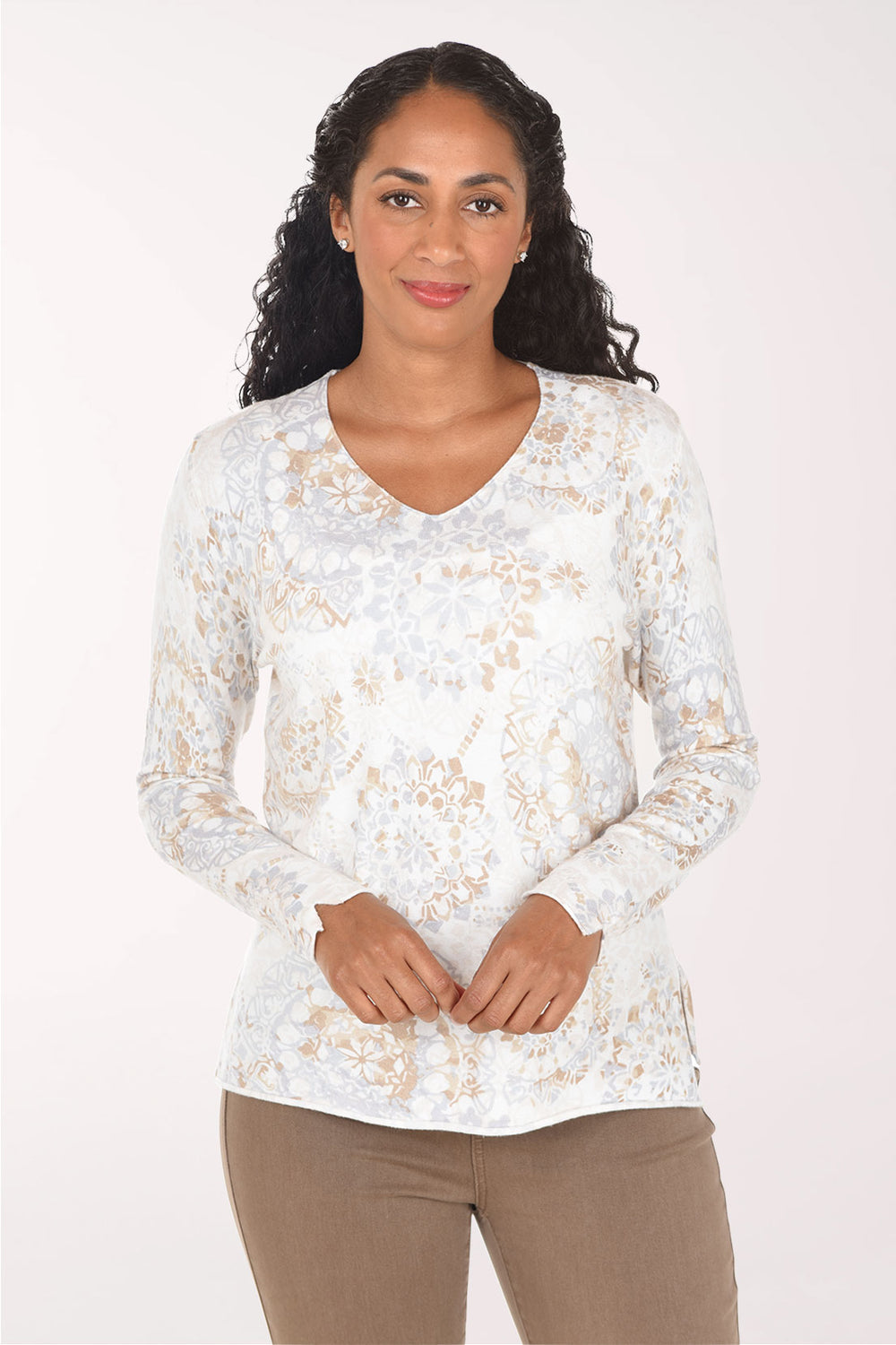 Woman wearing a long sleeve white sweater with a paisley print