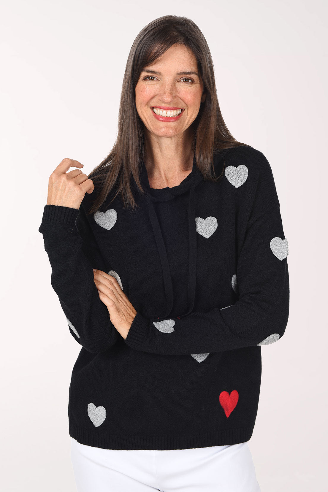 A close view of the black hoodie sweater showing the drawstring hood and grey and red embroidered hearts.