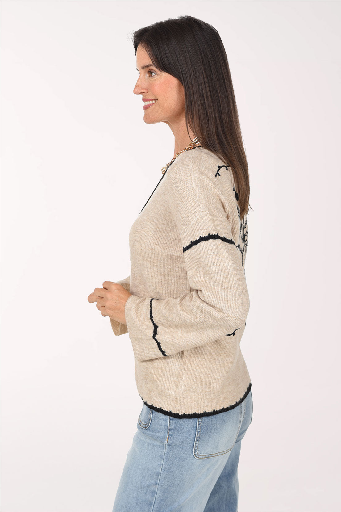 A side view of the almond knit sweater with black sleeve stripes.