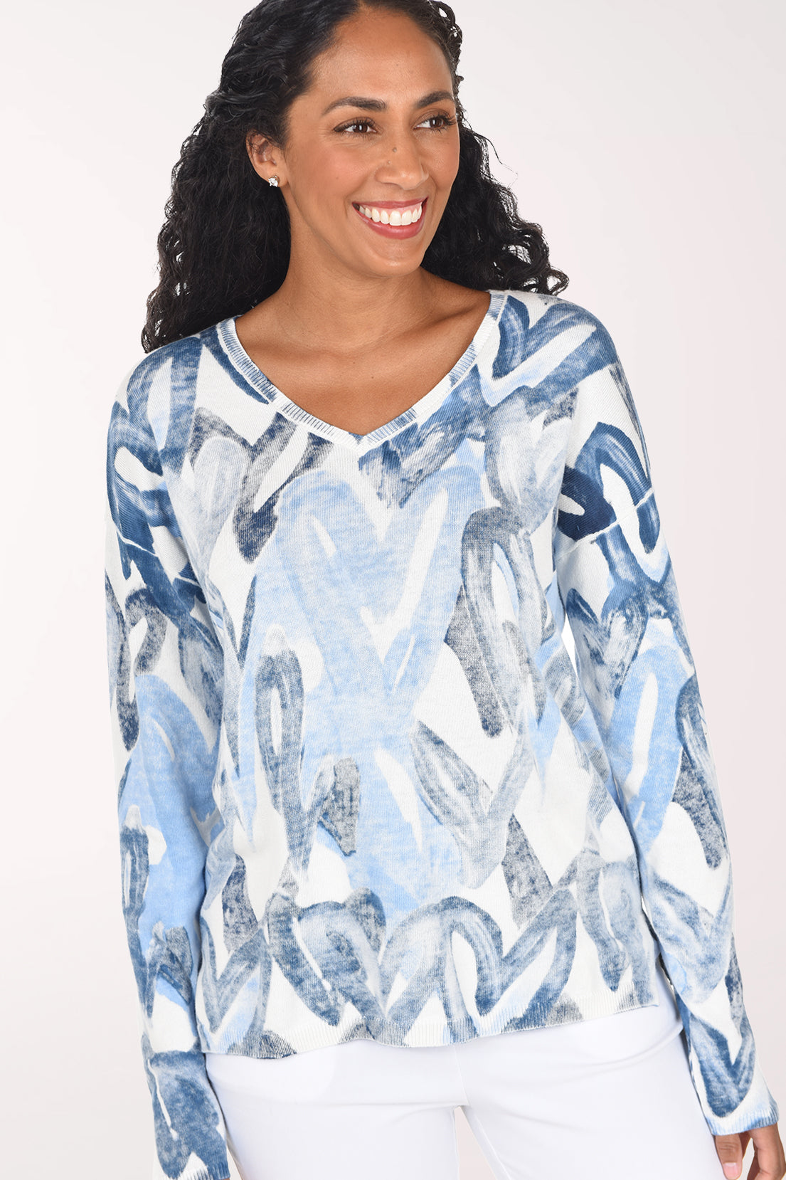 Woman wearing a long sleeve v-neck sweater with blue heart print