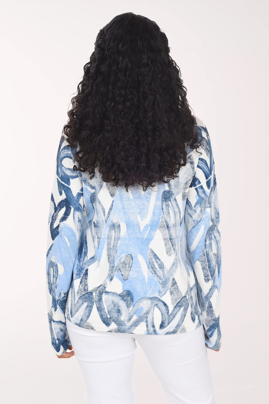 Woman wearing a long sleeve v-neck sweater with blue heart print