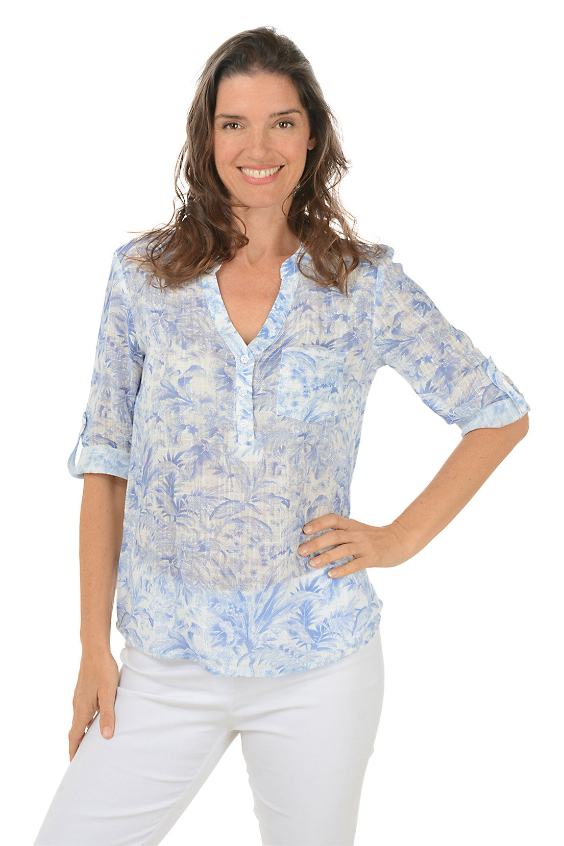 A woman wearing a blue and white floral split v-neck blouse with a mandarin collar and 3/4 sleeves with button roll tabs.