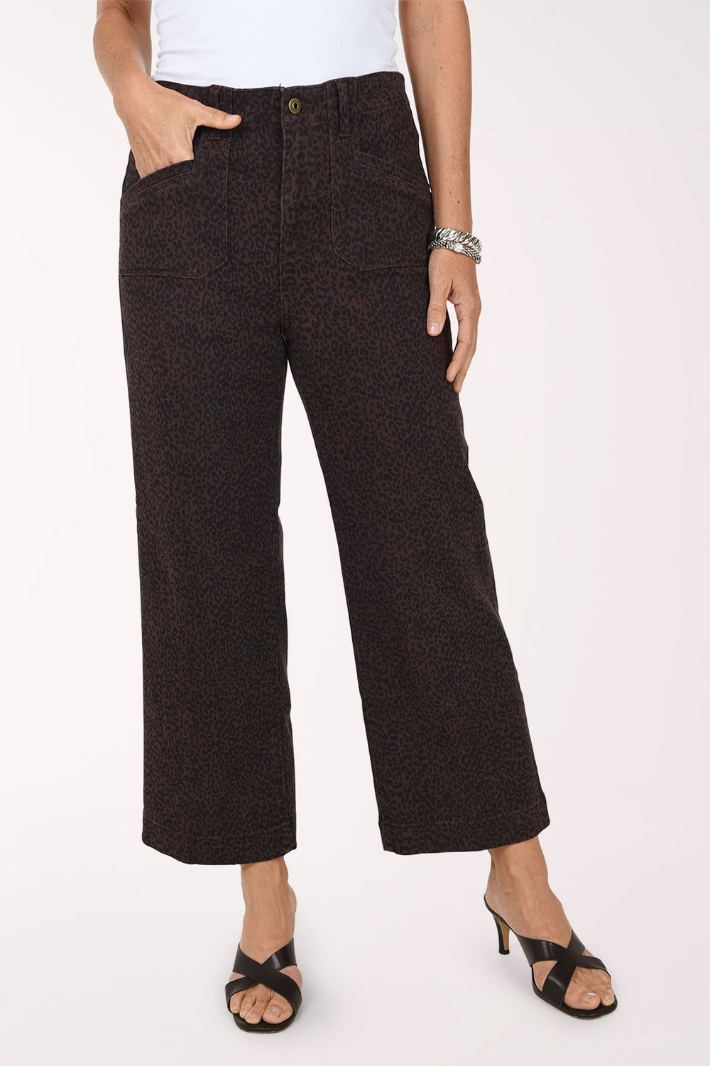 A front view of brown and black leopard print wide leg cropped jeans with front patch pockets, worn with a white top and black heeled sandals.