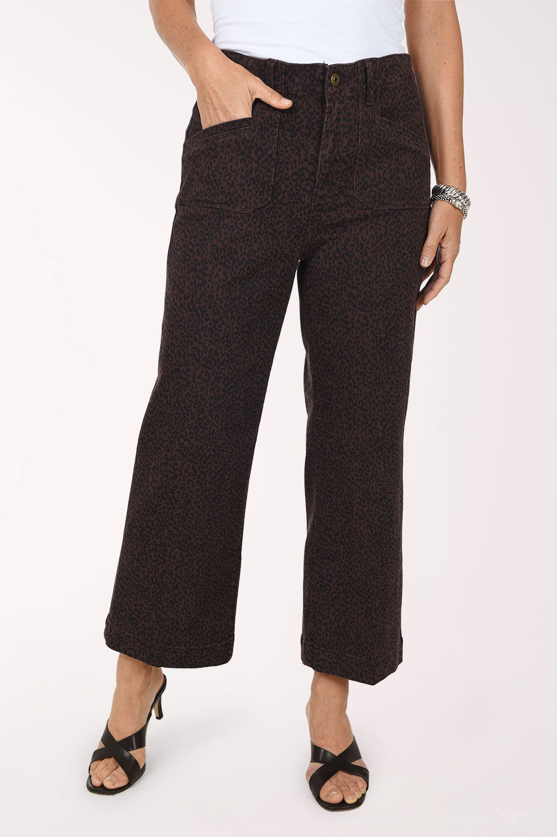 A front view of the brown leopard print wide leg jeans with a hand in the patch pocket.