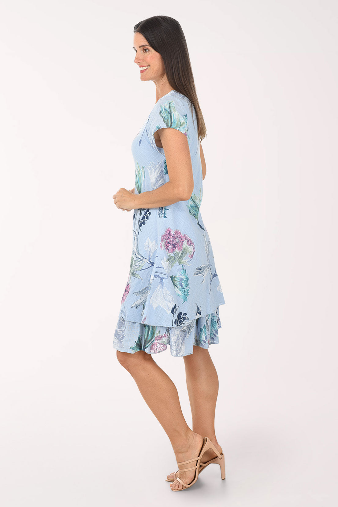 Woman wearing a light blue floral dress on a white background