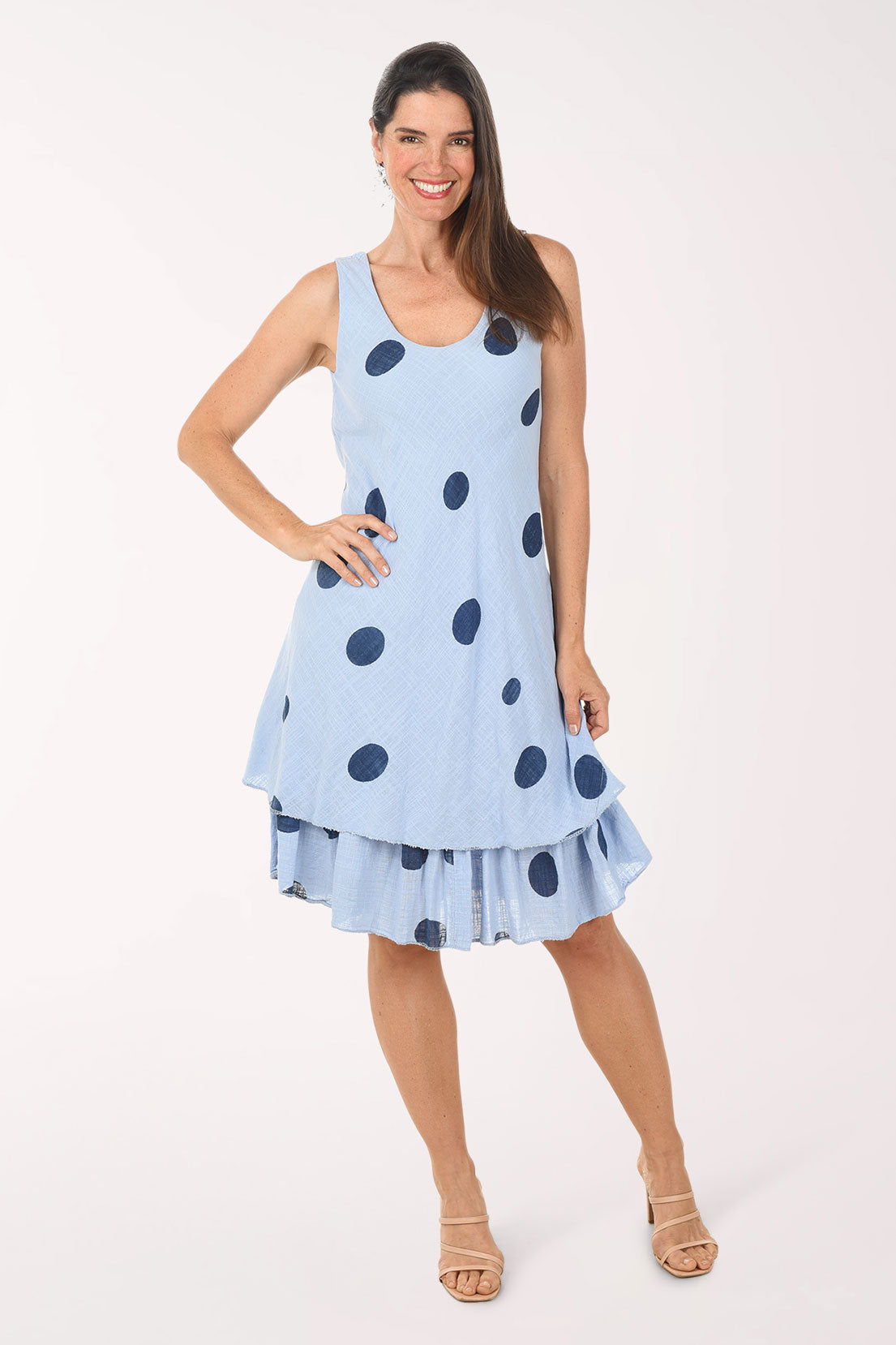 Woman wearing a light blue dress with dark polka dots on a white background