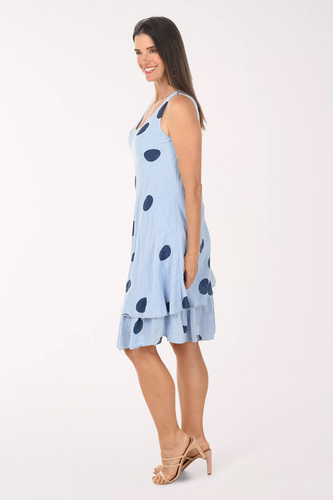 Woman wearing a light blue dress with dark polka dots on a white background