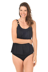 A woman wearing a solid black tankini top with adjustable shoulder straps and decorative ring detail on the shoulder.