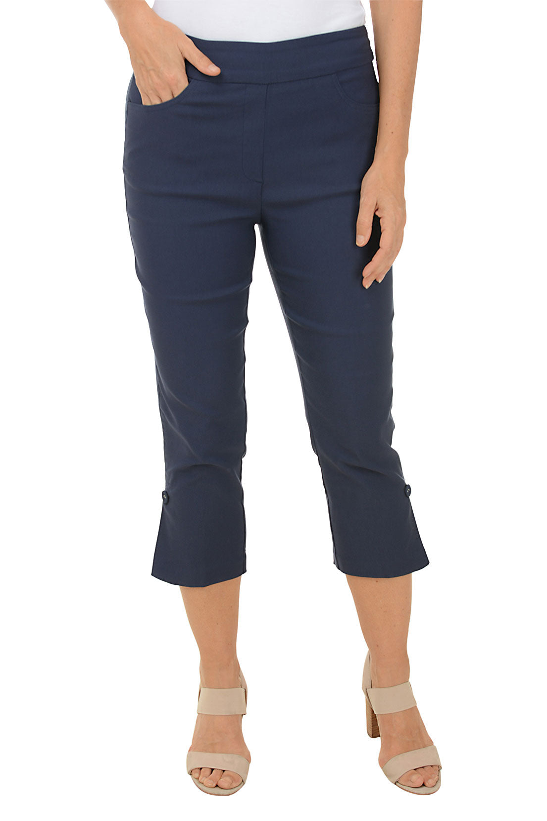 A model wearing navy pull-on capri pants with a button hem detail, standing against a plain background.