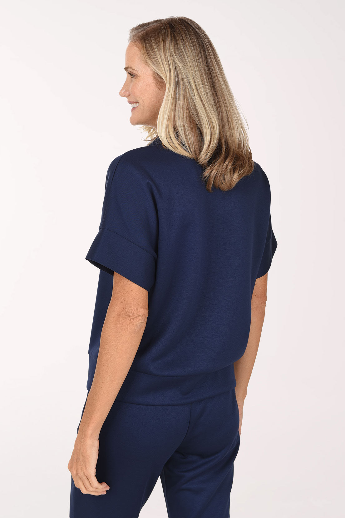Back view of the navy Jet Blue scuba polo top showing the collar, short dolman sleeves and straight hem.