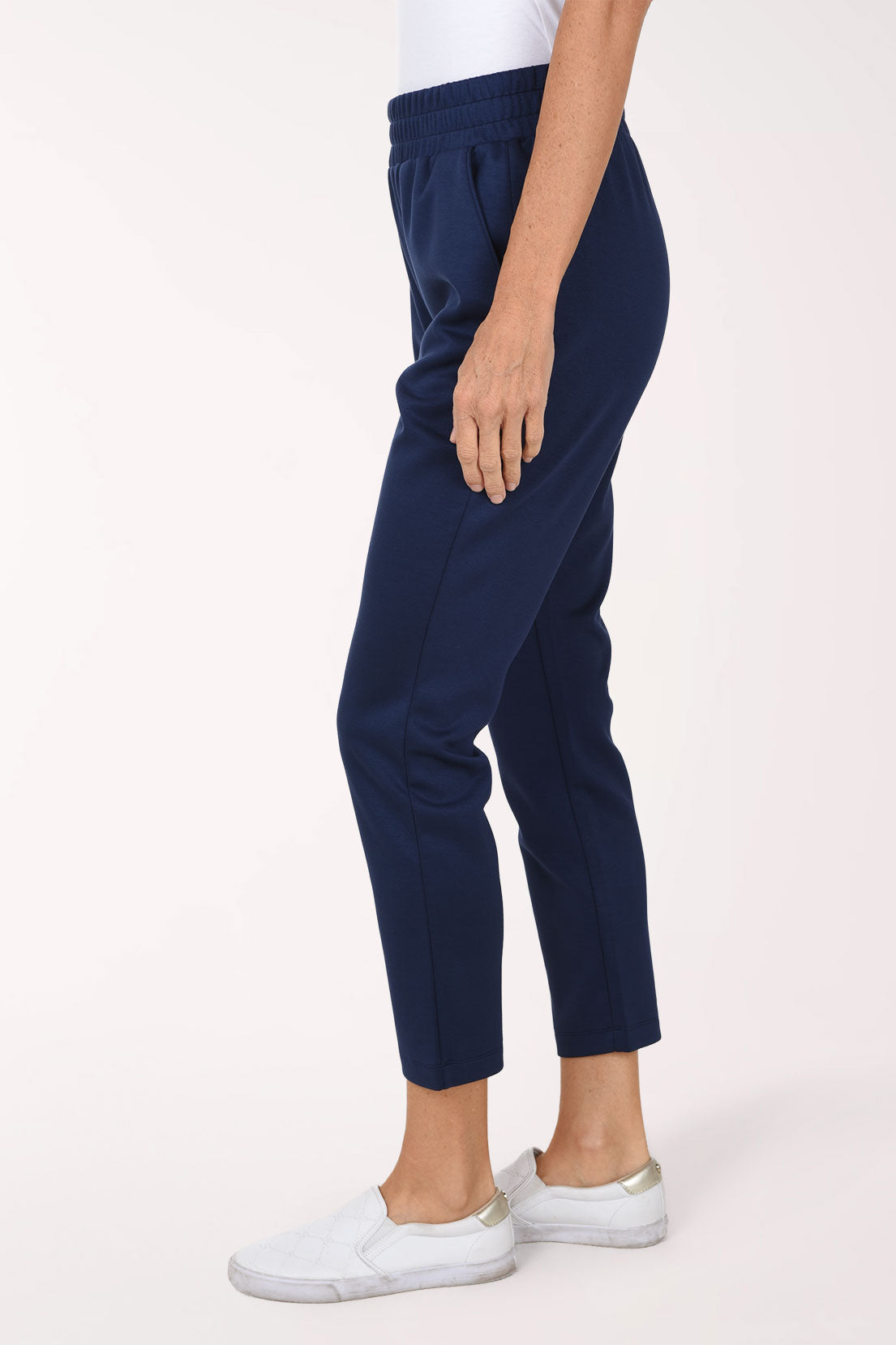 Side view of navy Jet Blue scuba straight leg pants showing the front pocket and the ankle-length straight leg.