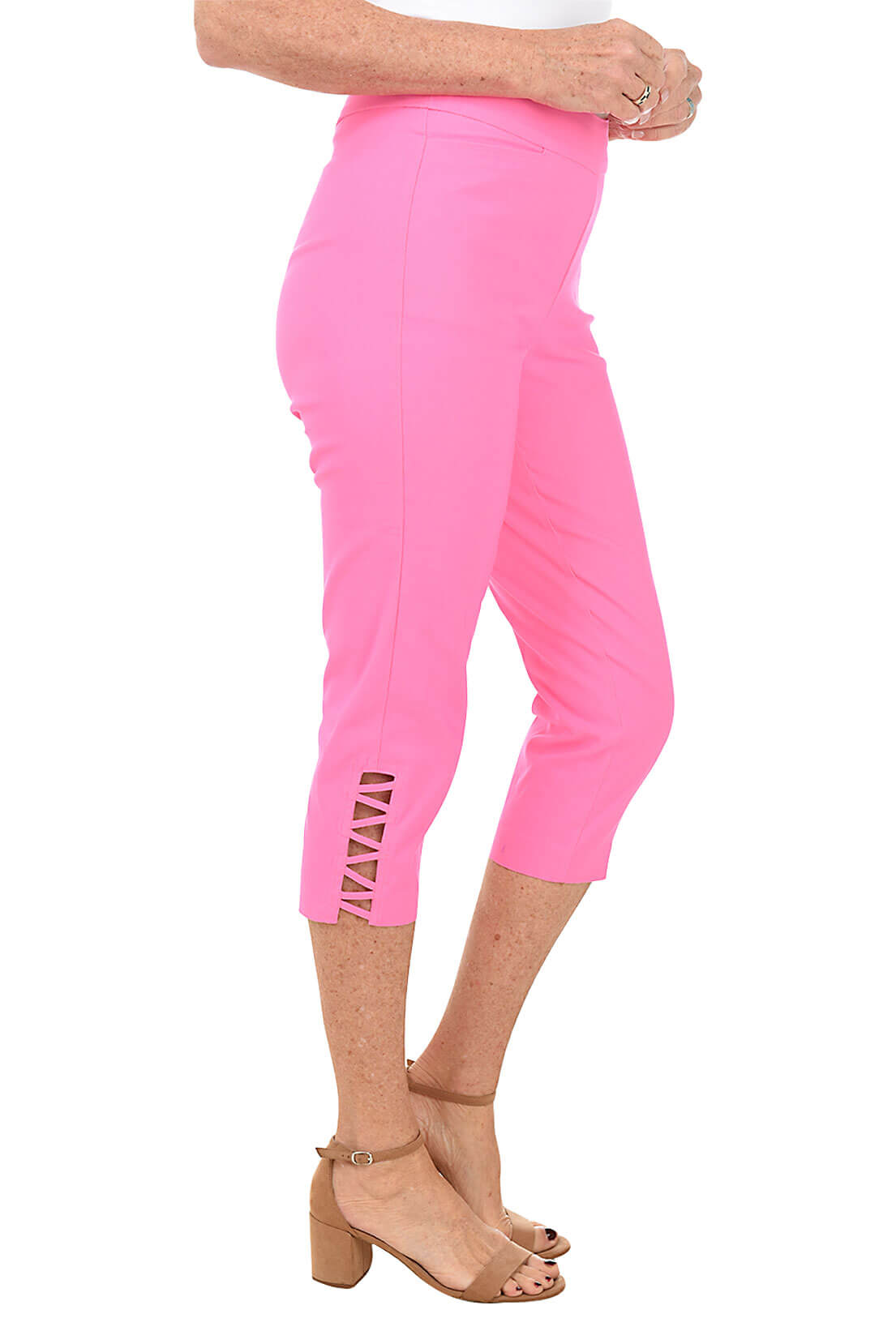 A pair of pink capri pants with lattice detail on the hemline, featuring front pockets and a flat back design. Side shot.