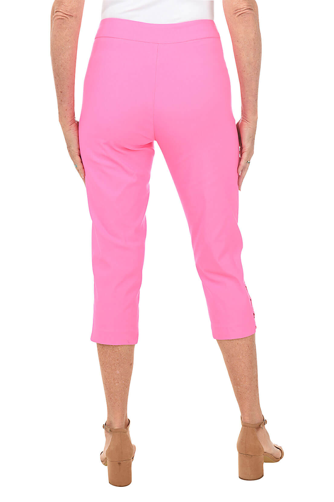 A pair of pink capri pants with lattice detail on the hemline, featuring front pockets and a flat back design. Back shot.
