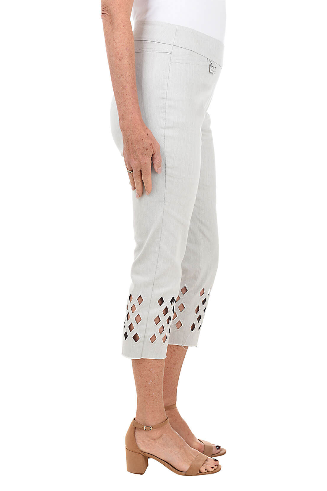 Light grey pants with cut-out details on a white background. Side shot.