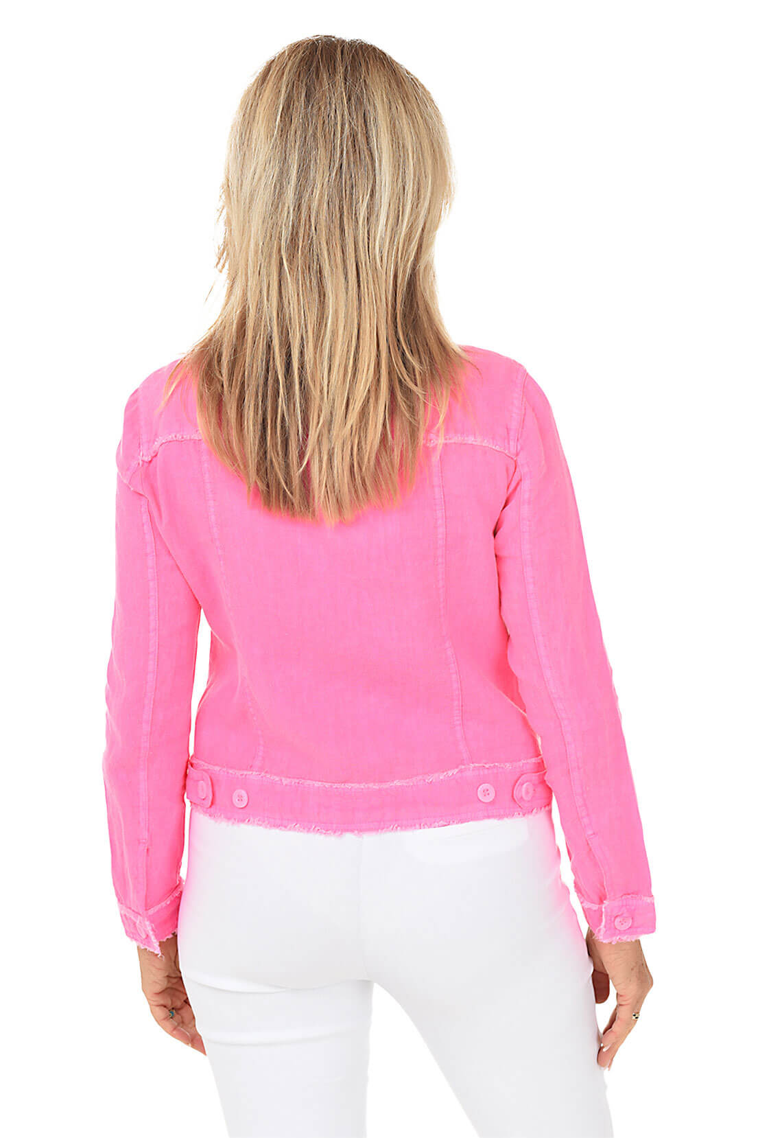 A rear view of a woman in a pink jacket and white pants against a white studio background.
