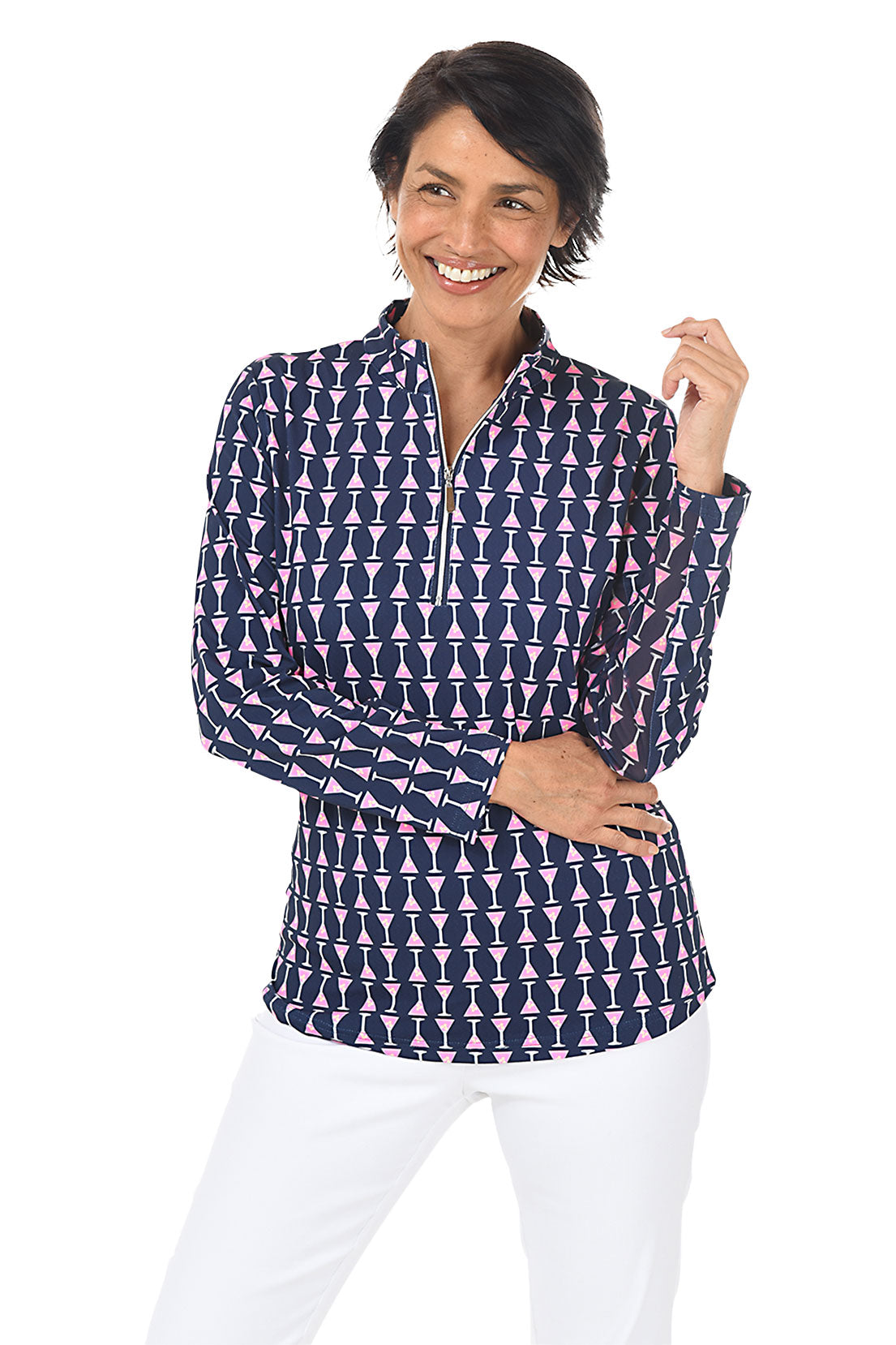 A woman wearing a long sleeve navy mock neck top with a martini glass pattern, paired with white pants. Front shot.