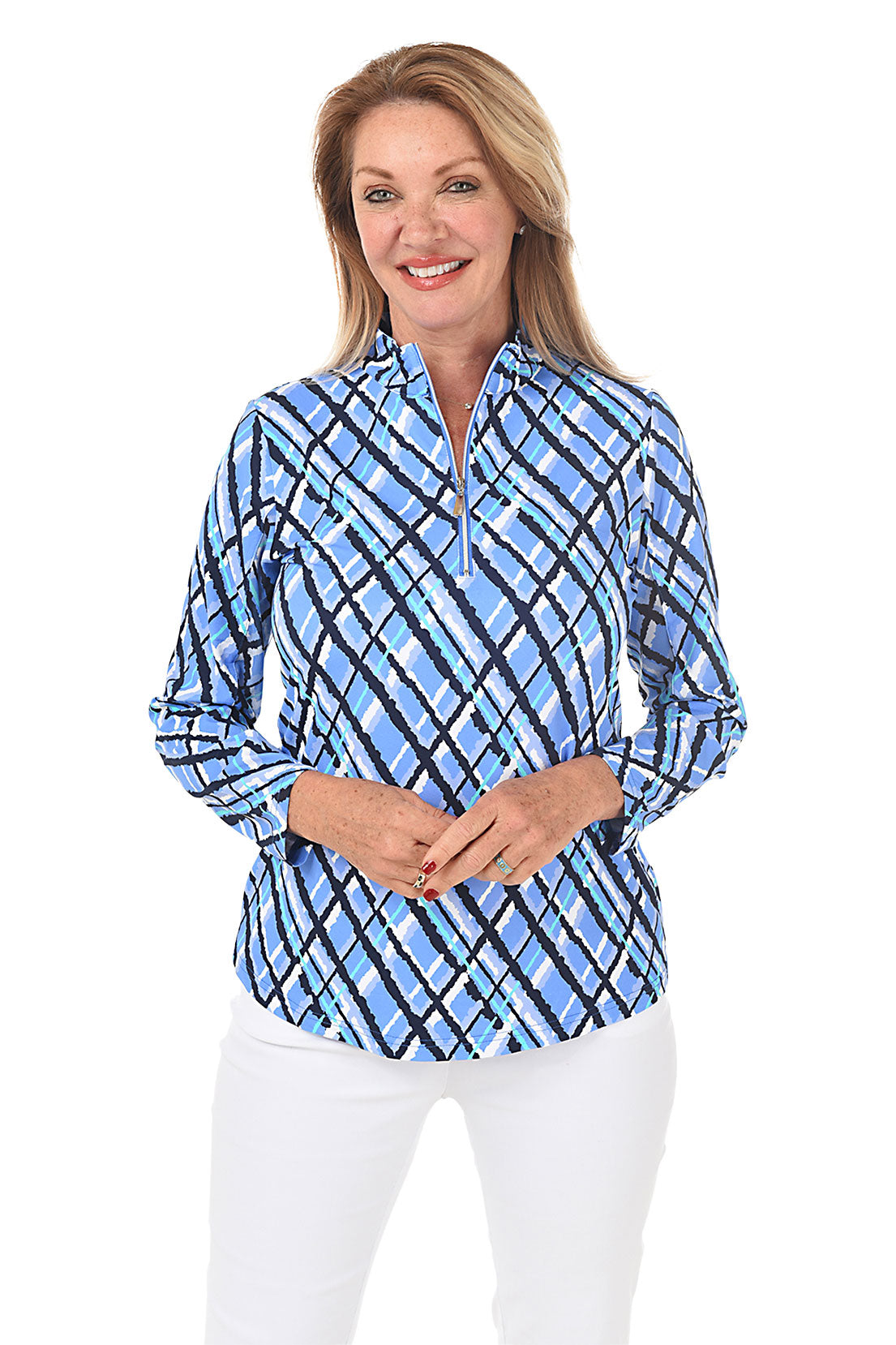 A woman wearing a blue and white plaid mock neck top with long sleeves, paired with white pants. Front shot.