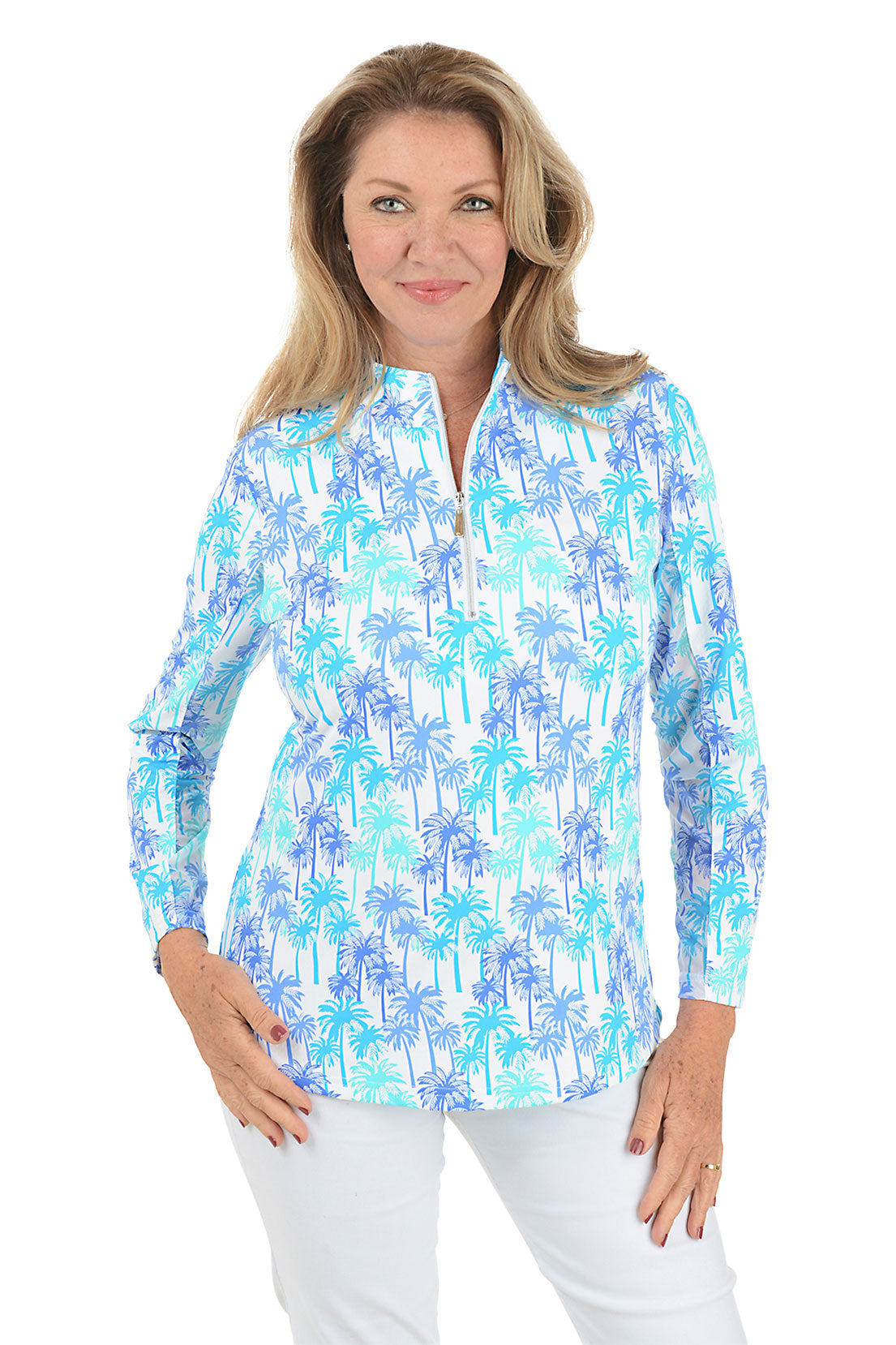 A woman wearing a long sleeve sun shirt with a mock neckline and a palm tree pattern in blue and white colors.