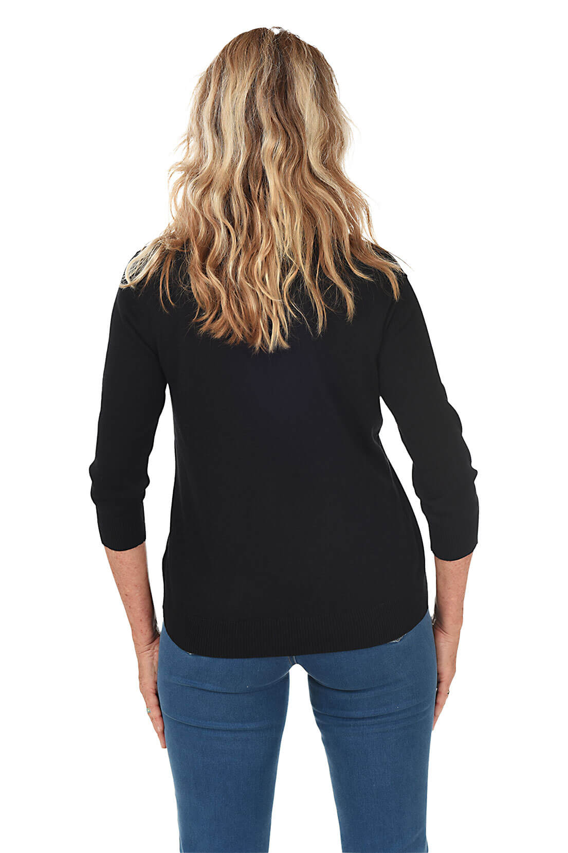 Back shot of a woman wearing a black cardigan over a white top and blue jeans on a white background