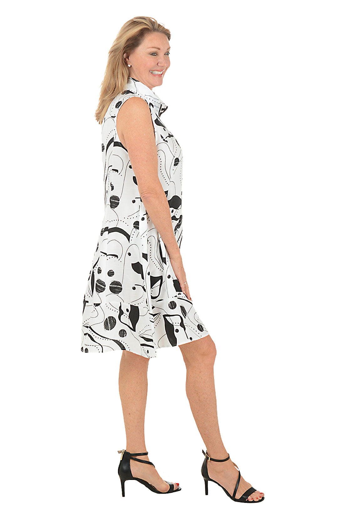 Woman wearing a sleeveless dress with black abstract pattern on a white background