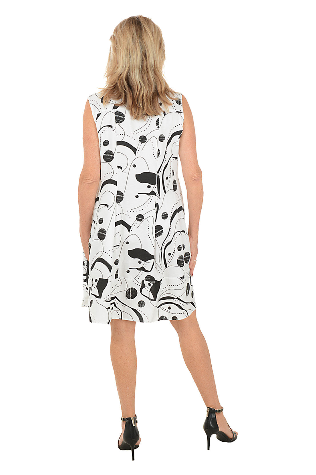 Woman wearing a sleeveless dress with black abstract pattern on a white background