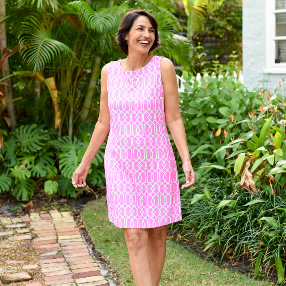 Woman in a pink dress standing in a garden