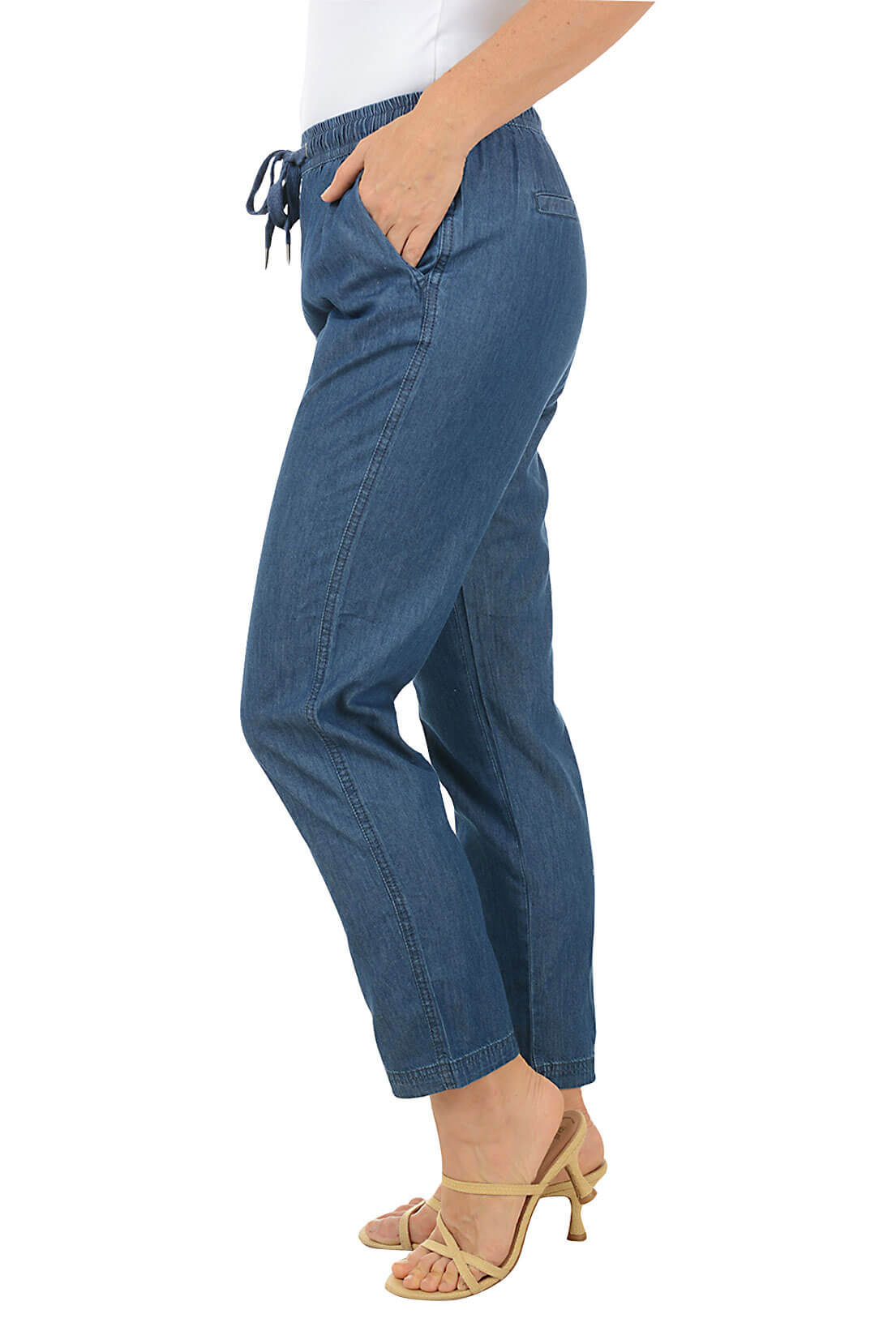 Blue jeans worn by a person on a white background. Side shot.