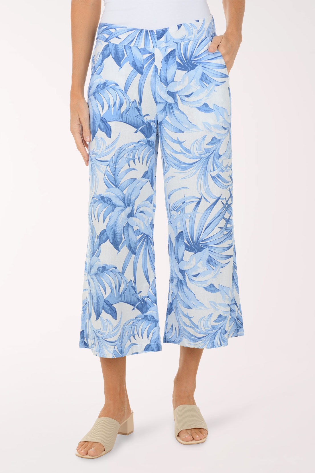 Person wearing blue tropical print pants on a white background