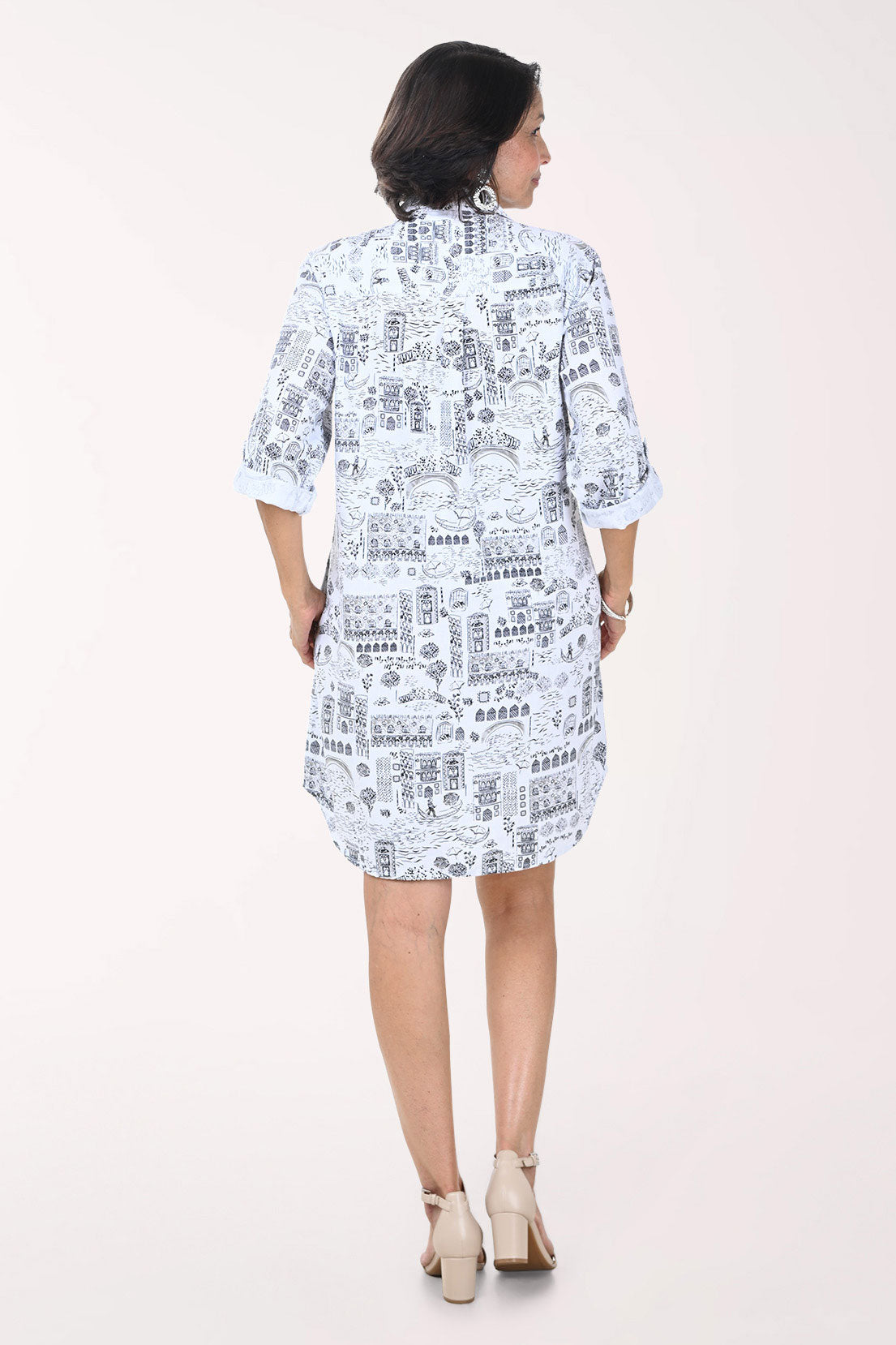 Woman wearing a white dress with black text pattern on a white background