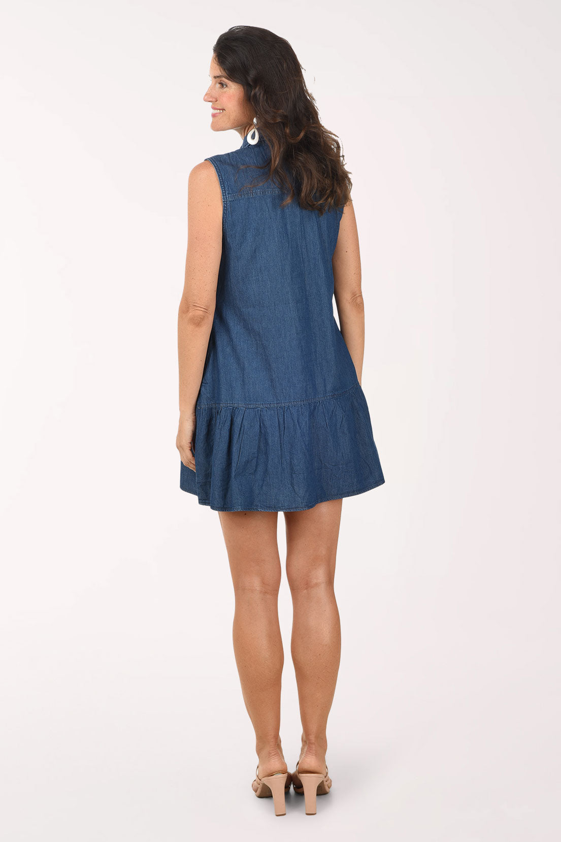 Woman wearing a blue denim dress on a white background