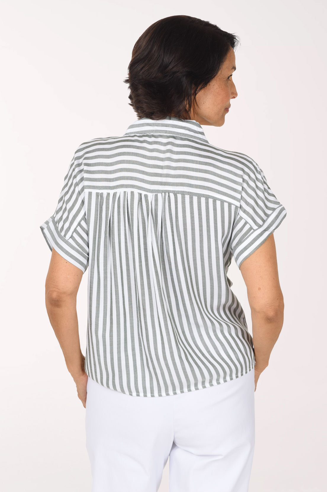 Woman wearing a seersucker olive green and white button down shirt with short sleeves and a tie bottom