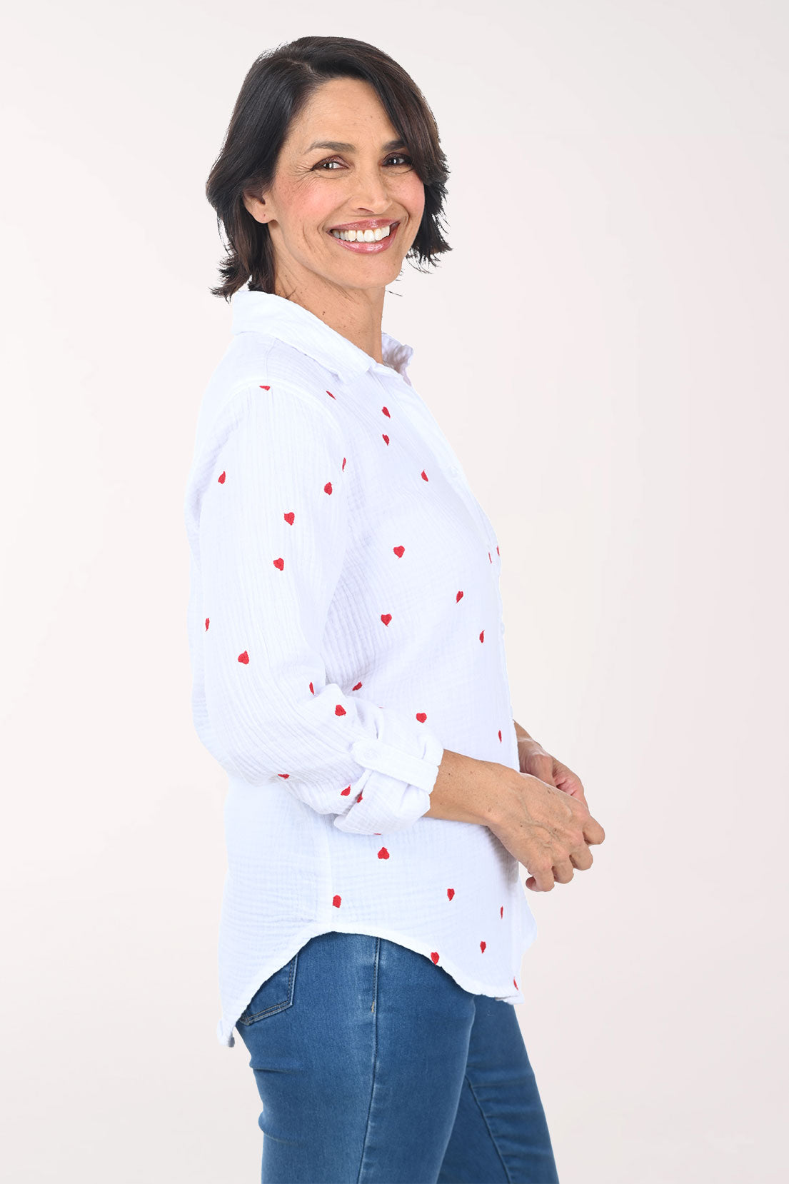 Woman wearing a white button down shirt with embroidered hearts