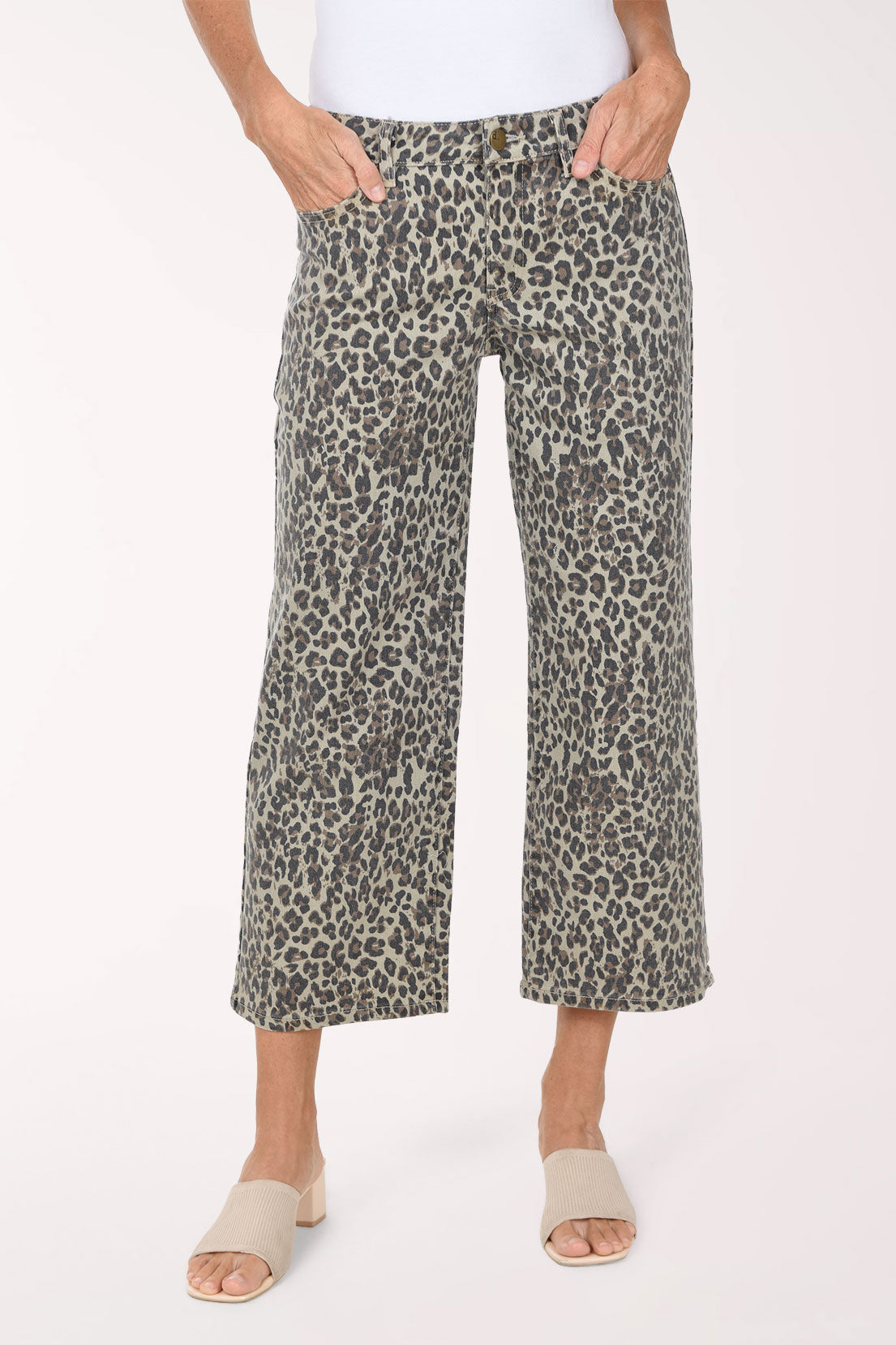 A person wearing cropped wide-leg pants with an olive green, black, and beige animal print, paired with a white top and beige slide sandals, against a plain white studio background.