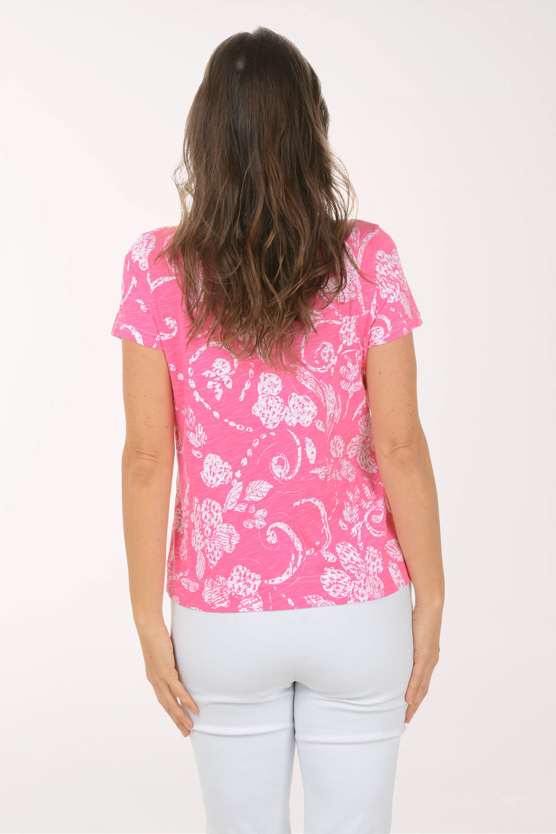 A woman wearing a short sleeve pink top.