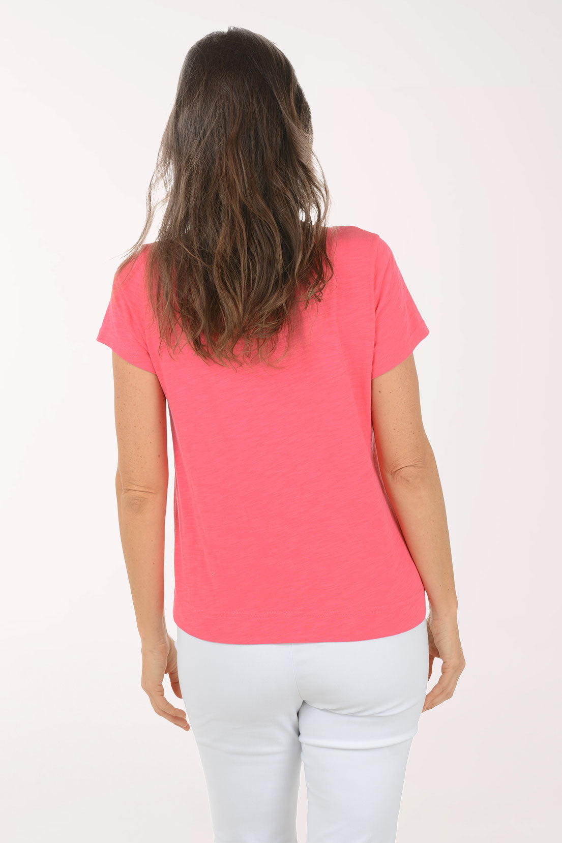 A woman wearing a short sleeve pink top with a turtle print.