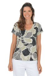 Woman wearing a floral patterned shirt on a white background.