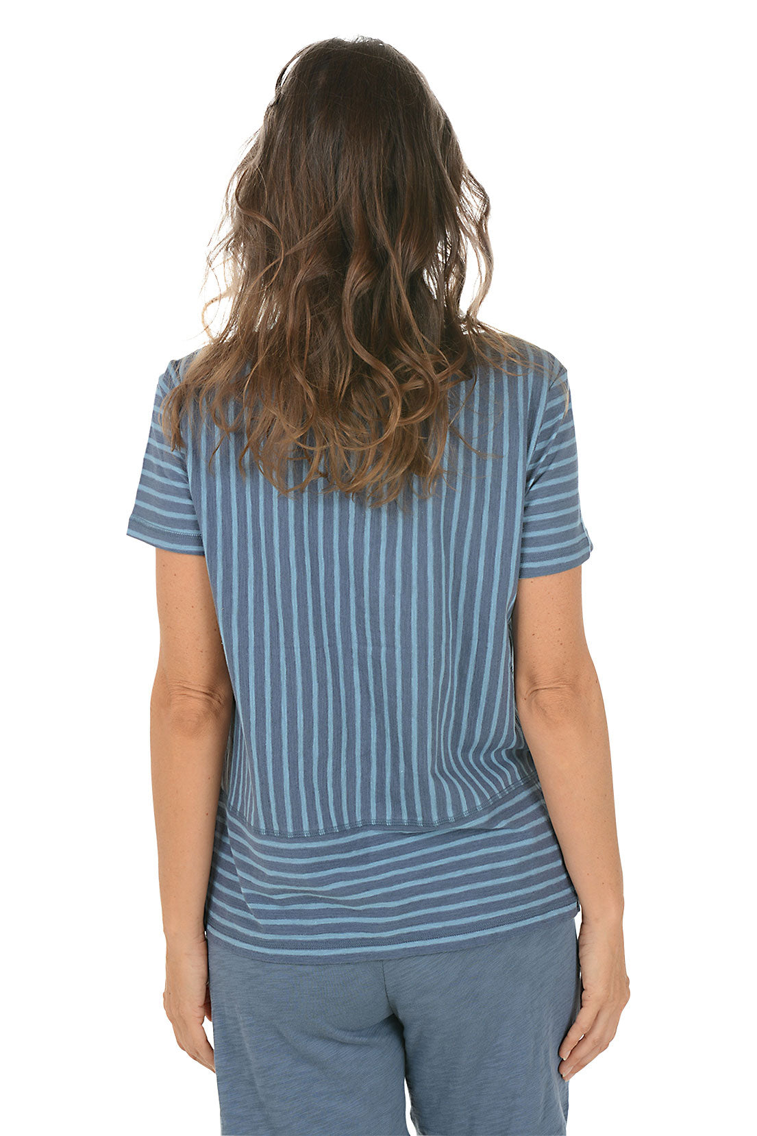 Woman wearing a blue striped shirt and pants on a white background. Back shot.