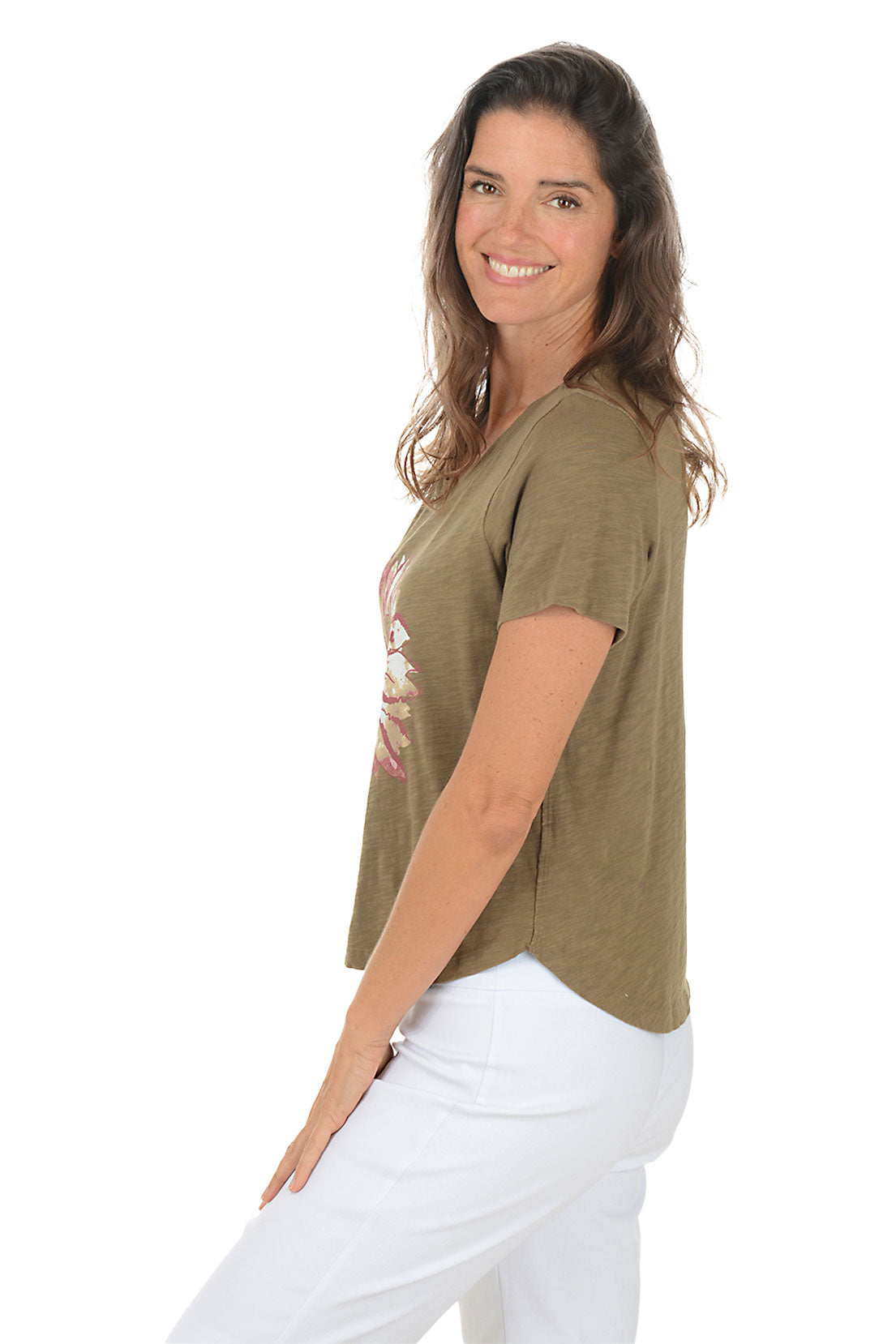 Woman wearing a green t-shirt with a pink floral design on a white background. Side shot.