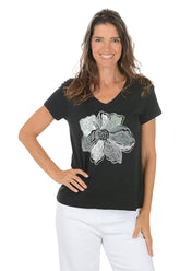 Woman wearing a black t-shirt with a floral design on a white background.