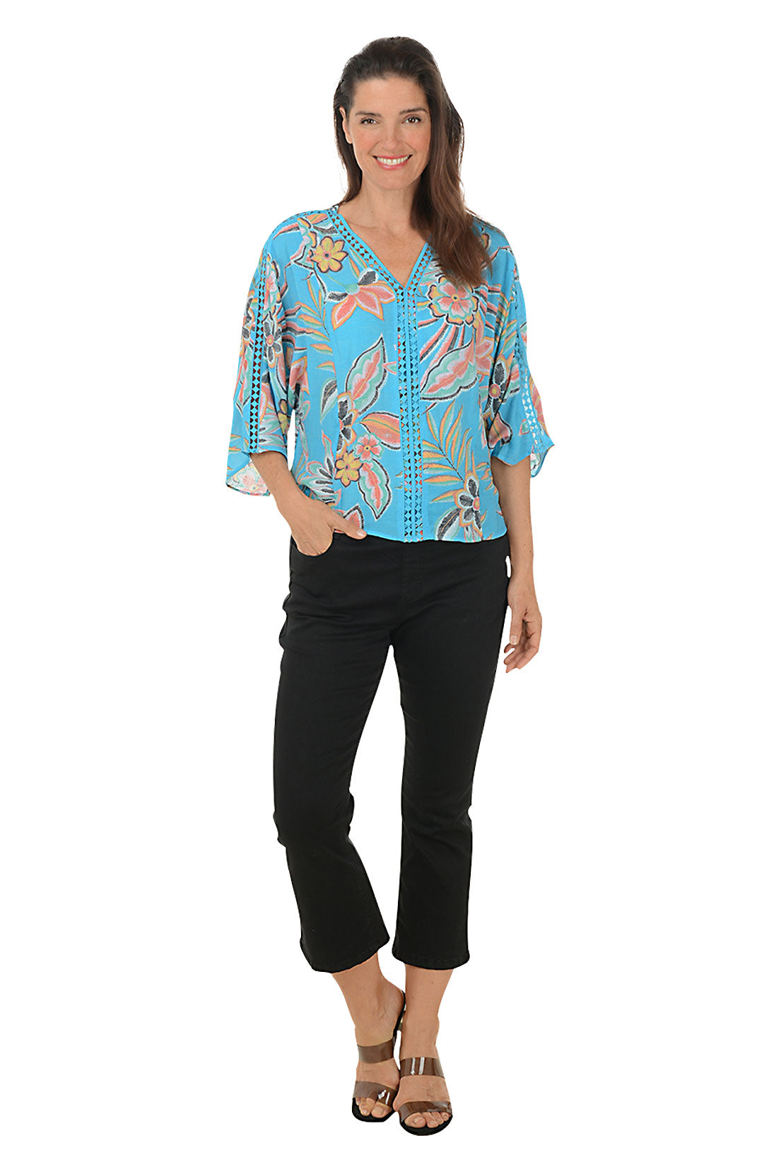 A pair of black denim crop pants with a flared leg and rhinestone button embellishment on the back hem, featuring a wide stretch waistband and belt loops. Full length shot.