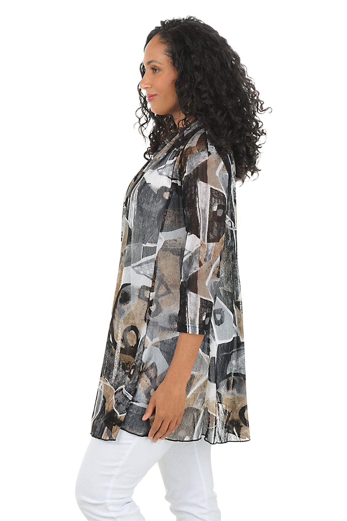 Woman wearing a patterned jacket over a white top on a white background. Side shot.