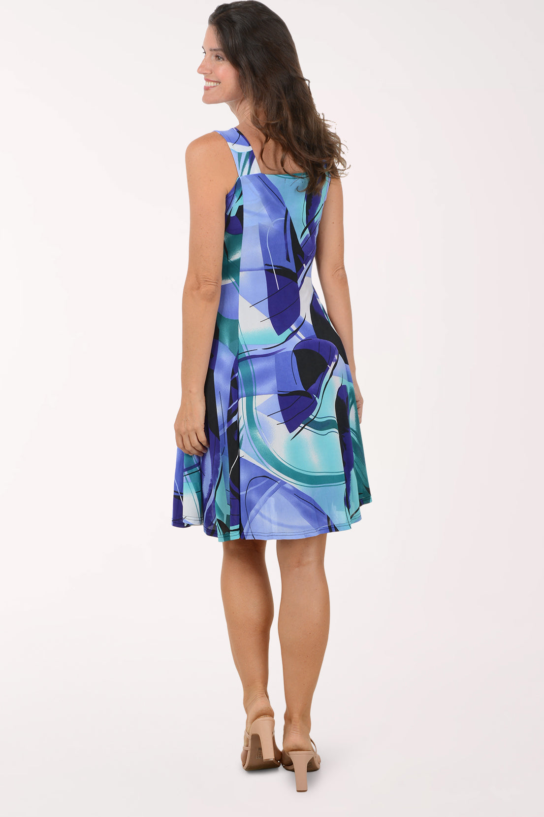 Woman wearing a colorful dress with abstract patterns on a white background