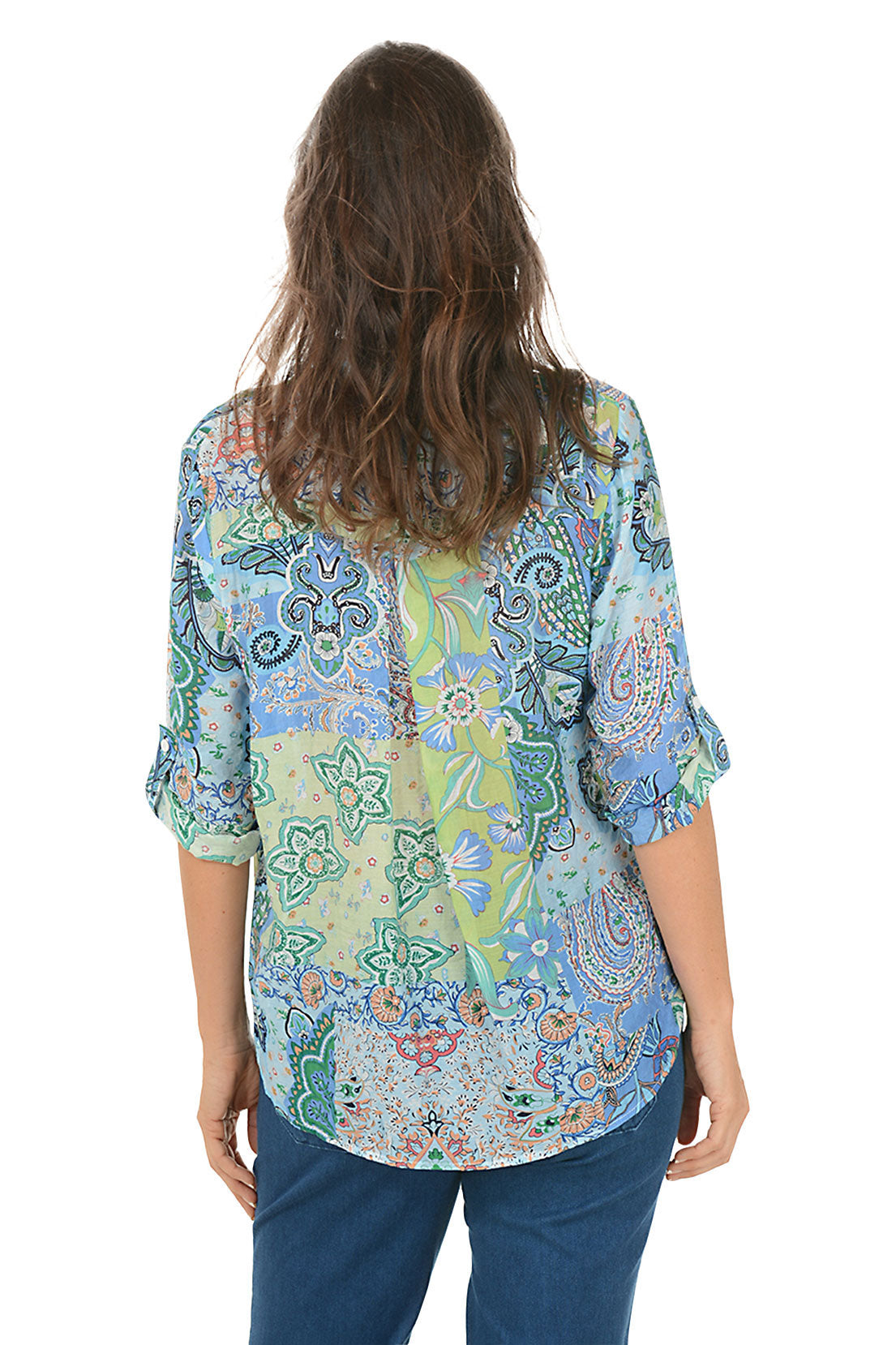 Woman wearing a colorful patterned shirt on a white background. Back shot.