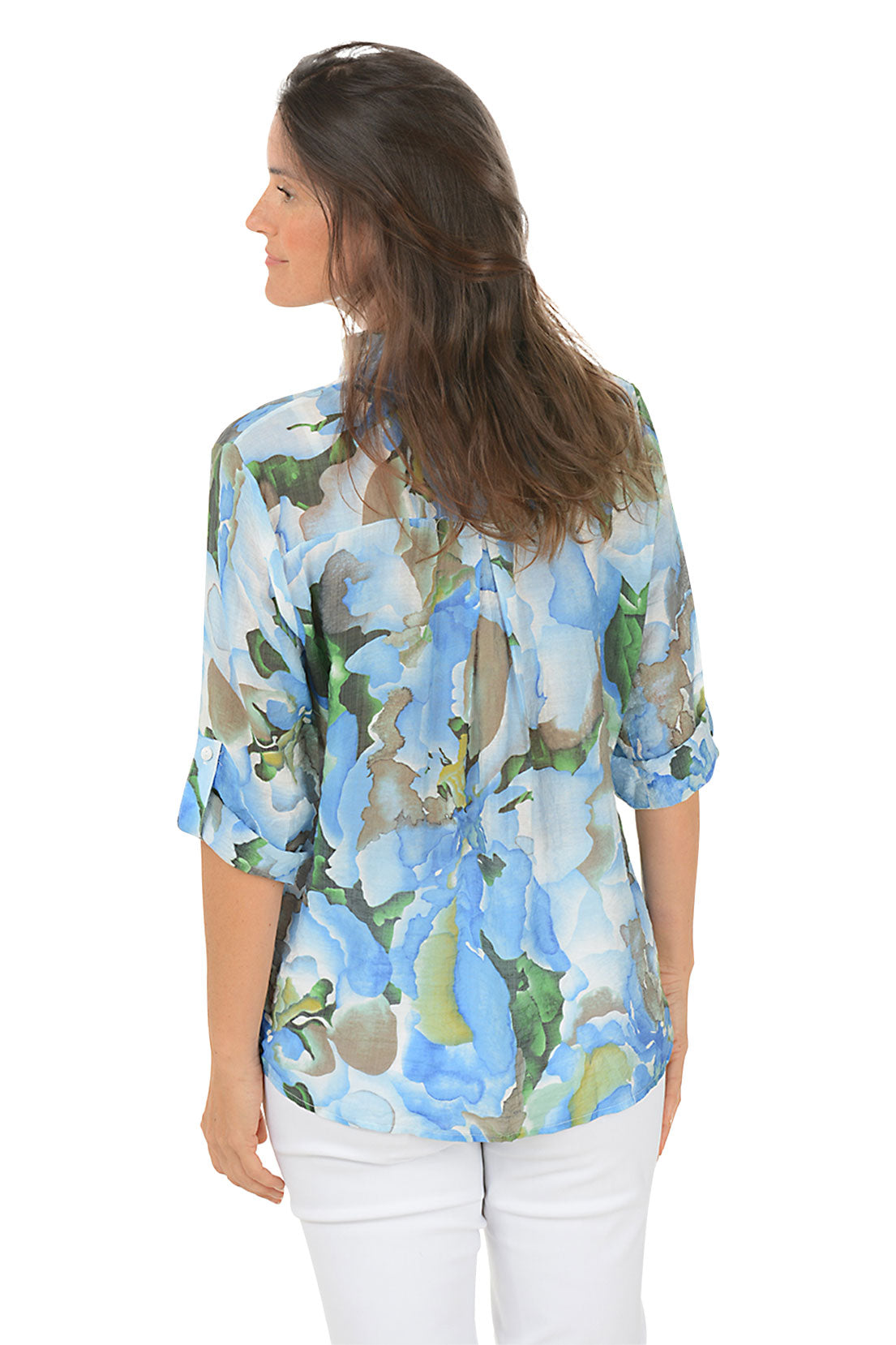 Woman wearing a floral blouse with a white background. Back shot.