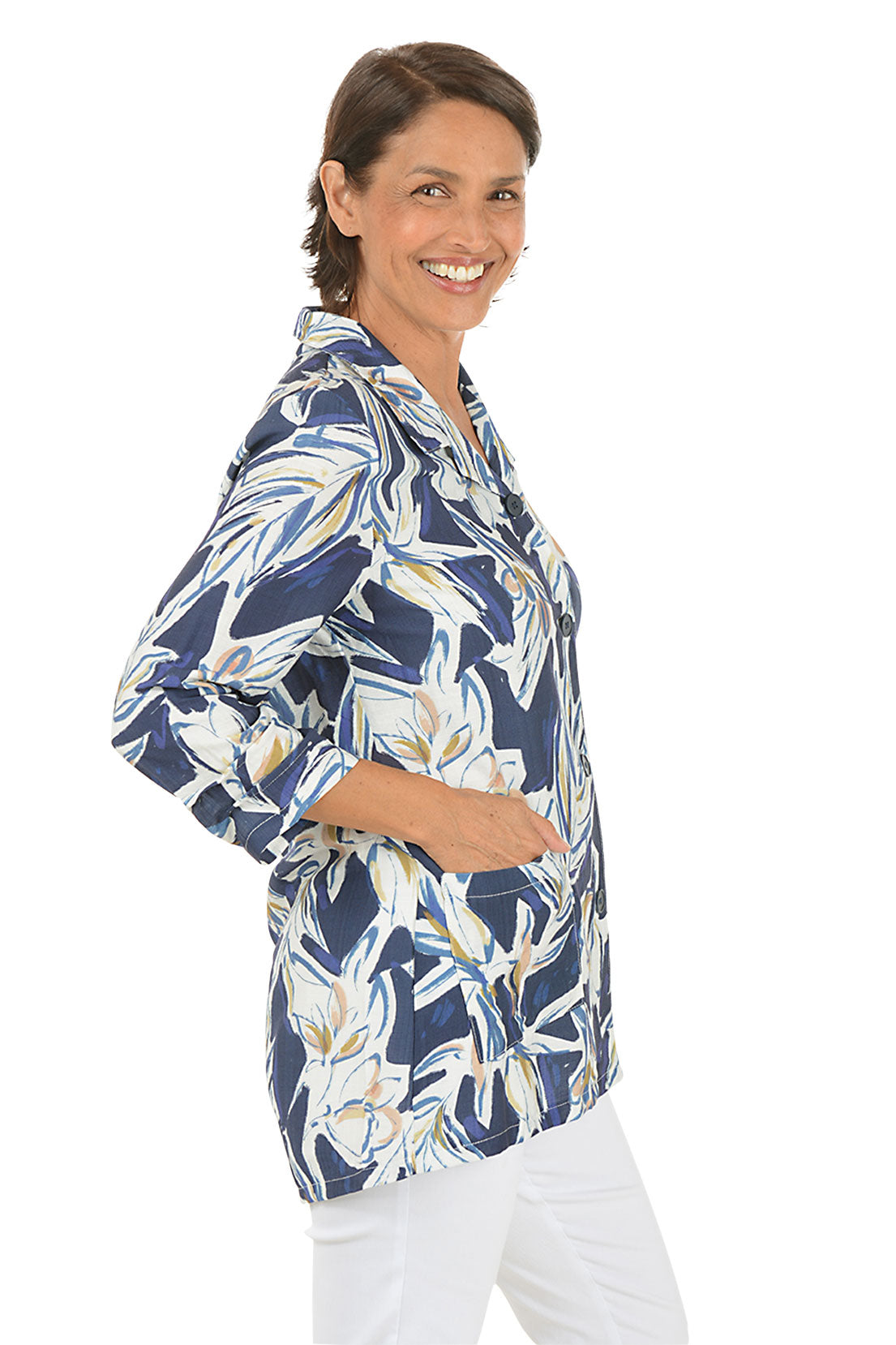 Woman wearing a blue floral patterned blouse on a white background. Side shot.