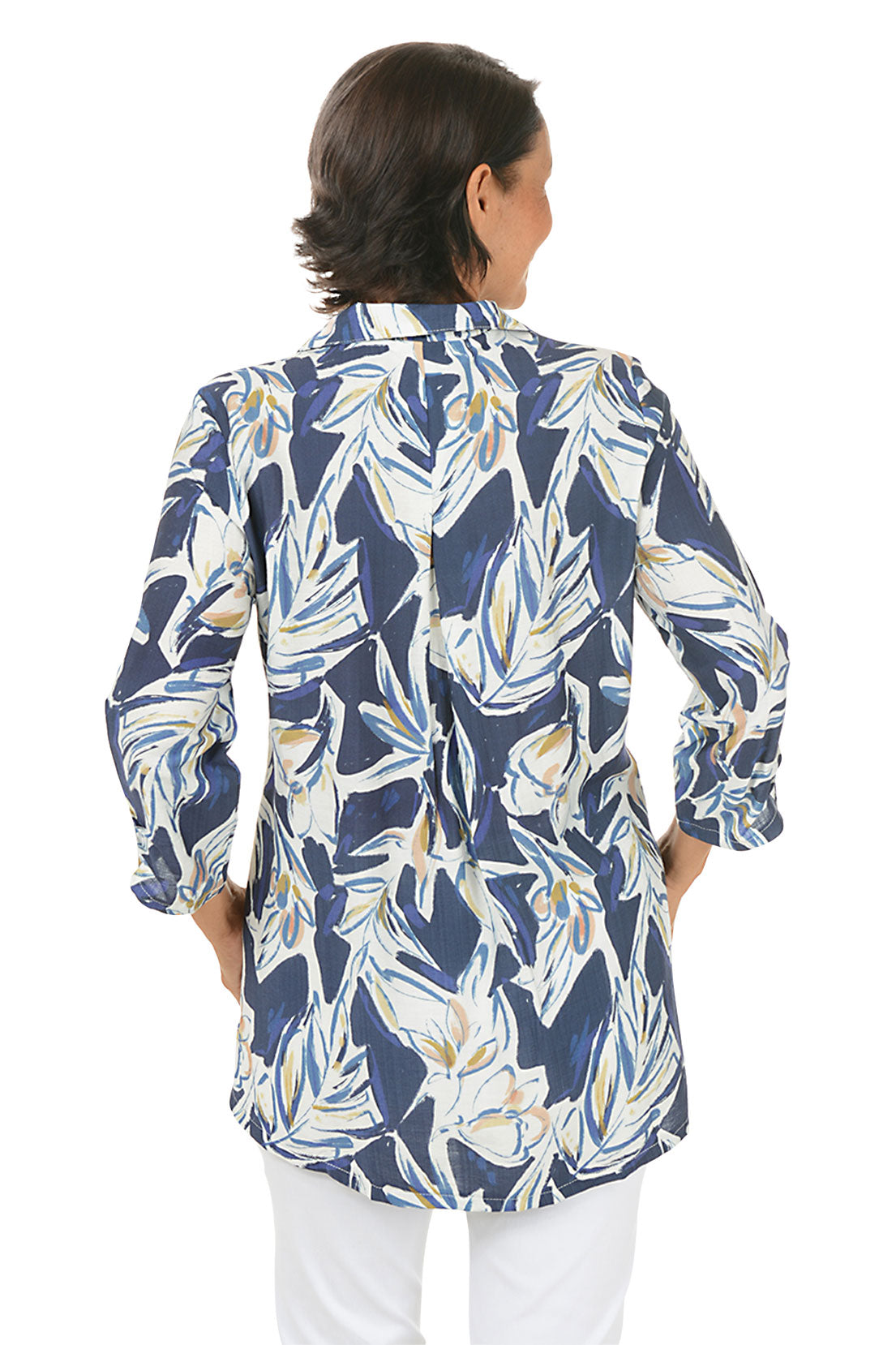Woman wearing a blue floral patterned blouse on a white background. Back shot.