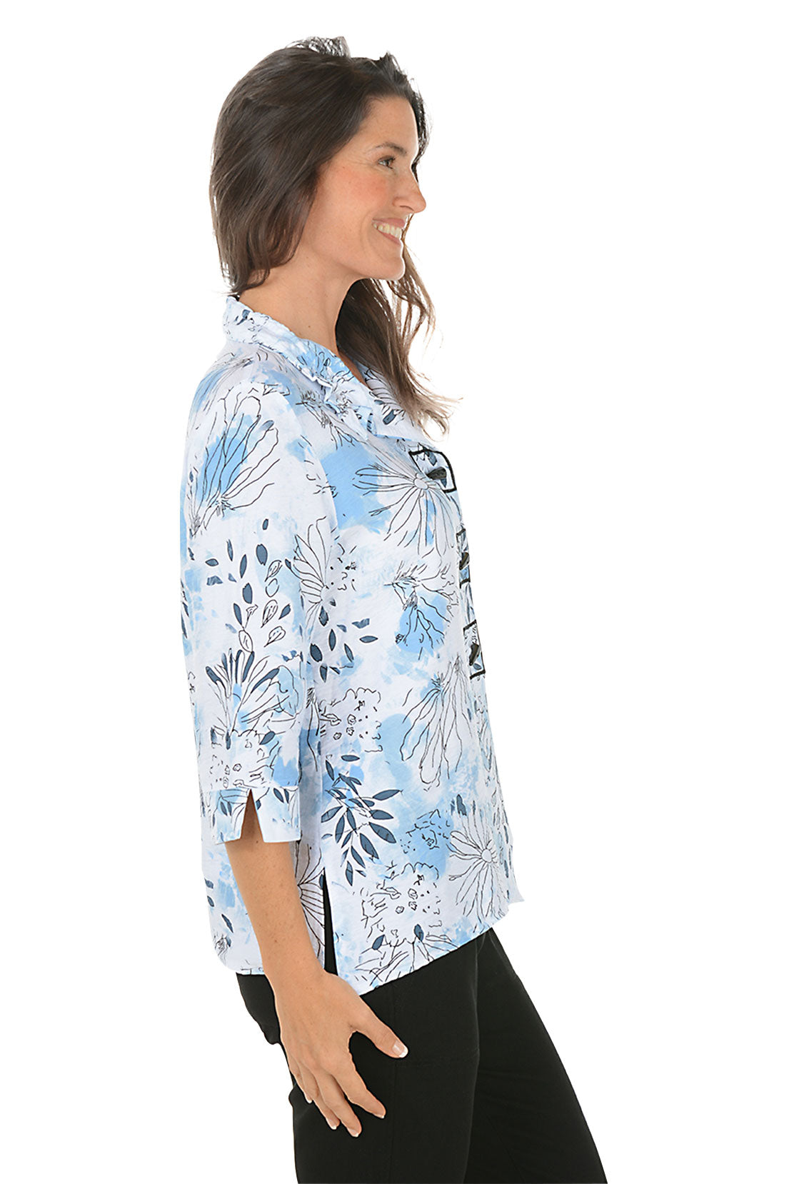 Woman wearing a floral patterned shirt on a white background. Side shot.