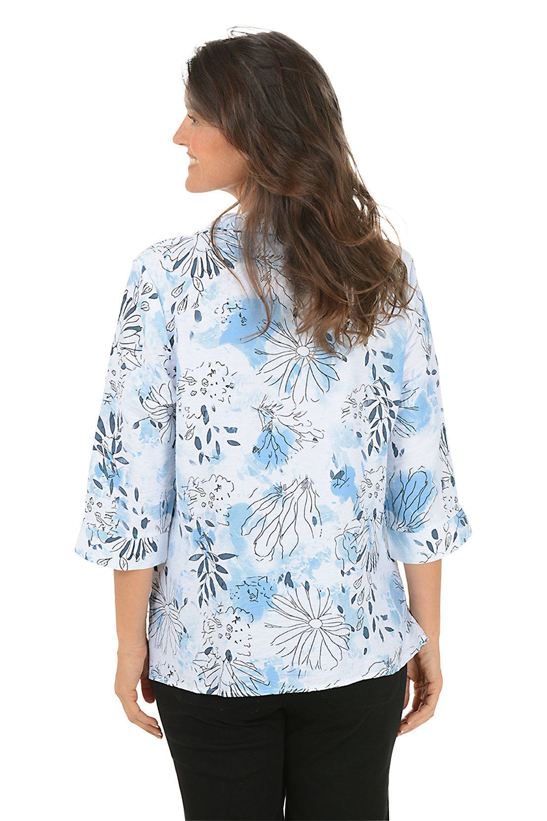 Woman wearing a floral patterned shirt on a white background. Back shot.